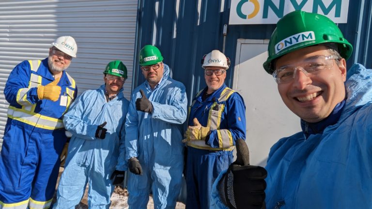 Cinq hommes pose en habits de protections devant une usine de bioénergies et de bioproduits.