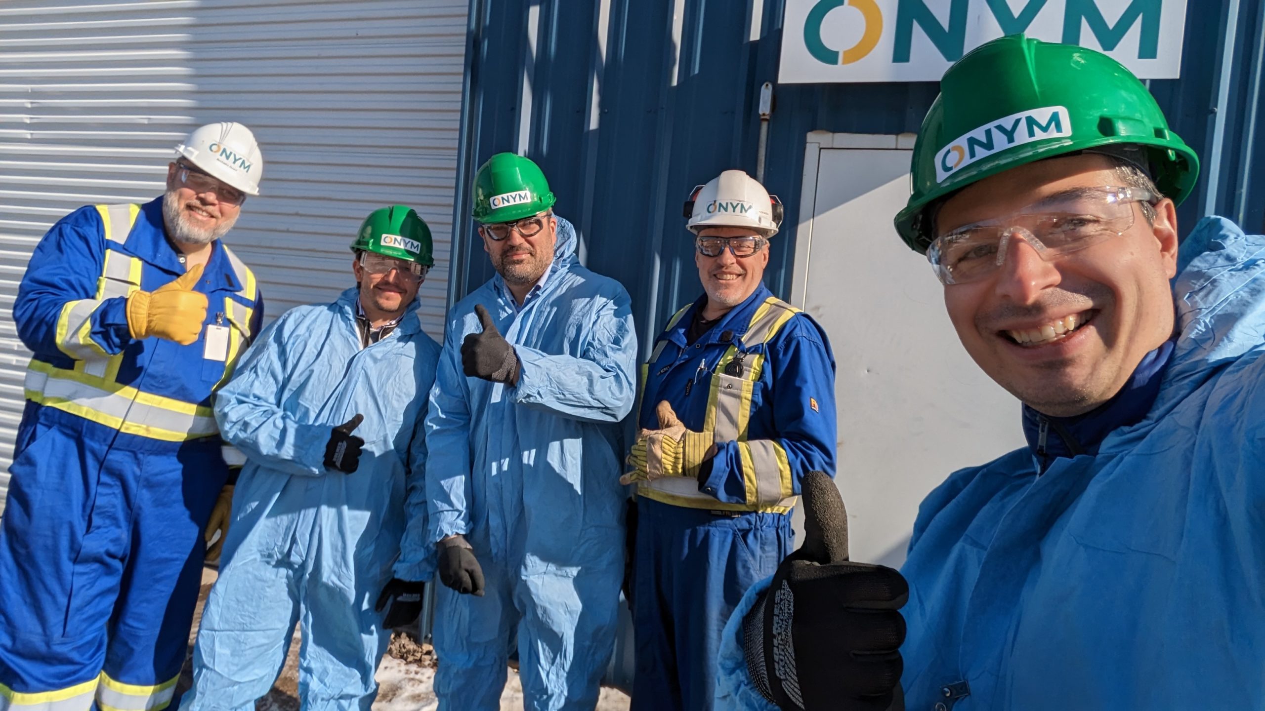 Cinq hommes pose en habits de protections devant une usine de bioénergies et de bioproduits.